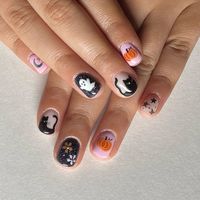 These nails feature a nude pink base adorned with cute Halloween designs, including a glittery ghost, a playful black cat, and a charming pumpkin.  🍂 Recreate this look yourself with our Korean Gel Nail Polish collection!  🍂 Credit: gelnails_byhannah on Instagram 🍂 fall nail art, fall nails, fall nail designs, October nails, autumn nails, early fall nails, cute fall nails ideas autumn, fall nails ideas autumn, fall gel nails, Halloween nails, cute Halloween nails, ghost nail art, pumpkin nail design, black cat nails, glittery nails, Korean gel nails, short fall nails, short halloween nails, black nails