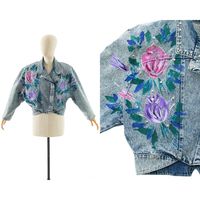 Please Enlarge Photos For More Detail D E T A I L S 1990s Jean Jacket Acid Wash Light Blue Cotton Denim Hand-Painted Roses In Pink, Purple, Green, Blue, White Decorated With Glitter Adorned With Silver-Tone Round Metal Studs + Silver-Tone Metal Set Rhinestones Lapel Collar Tapered Dolman Sleeves Attached Shoulder Pads Cropped Length Metal Snap Closures Up The Front Unlined Label: Made In Usa M E A S U R E M E N T S Fits Like A: Large Shoulders: Undefined, 17" (From End To End Of Shoulder Pads) Bust: About Up To 44/45" Waist: 33/34" Length: 19.5" To Waist, 22" To Hem Sleeve Length: 12.5" (Along Inseam), About 22" (From Edge Of Shoulder