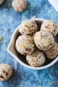 Overhead view of a bowl of Lemon Coconut Cashew Date Balls on a blue background