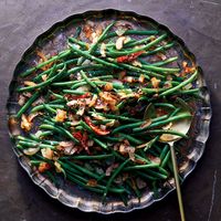 Caramelized Coconut Green Beans | Chef Biju Thomas pairs crisp-tender green beans with chunks of fresh coconut in his Caramelized Coconut Green Beans. Get the recipe at Food & Wine.