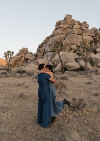 Engagement photos at Cap Rock, Joshua Tree National Park. LGBTQ+ couple photos. Denim engagement outfits. Desert engagement. Editorial and candid photography.