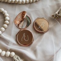 "Our unique personalized compact pocket mirror makes for the perfect bridesmaid gift!  Convenient for on the go and last minute touch ups on your wedding day or as special thank you keepsakes for your bridesmaids! Your choice of compact colours are rose gold, gold or black. Choose from a variety of font option and colours as well! Approximately 3\" across by 1/2\" in thickness. Dual sided mirrors with one regular mirror and one 2x magnification.  A beautiful sheer white organza gift bag is included with each compact purchased ! If you have any questions please send me a message!"