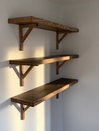 Chunky solid oak shelves supported on oak gallows brackets. Oak shelves have been coloured with a dark wax/oil.