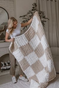 Each blanket measures 50" x 60" and is made from 100% Chenille Polyester, ensuring ultimate softness and warmth. The classic checkered design features a soothing palette of Soft White and Cream, perfect for adding a touch of elegance to any space. Dimensions: 50" x 60" 100% Chenille Polyester Colours: Soft White, and Cream This is a handmade item which means each blanket may vary slightly. If you require shipping, blanket will be vacuum sealed to save on shipping costs.  Care Instructions: Spot