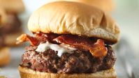 Crispy bacon and tangy blue cheese dressing add their distinctive flavor to burgers cooked on the grill.