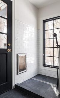 Black and white dog shower in a contemporary mudroom with black slate floor tiles contrasted with white subway wall tiles. A tall black framed window compliments the door making this shower unique and inviting. via - Alec Williams Construction