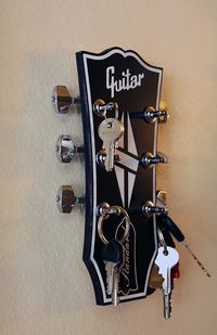 Hello guitar lovers!!!! Turn some heads with this amazing looking key holder. Designed in the style of a Gibson Les Paul, one of the most iconic and easily recognized guitars ever made!!! The face of the rack is made from two tone acrylic with a wood back and comes with actual chrome