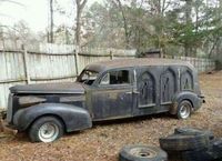 abandoned hearse, gothic arch windows.