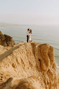 san diego beach session shoot photographer engagement couples cliffs beach la jolla ucsd glider port warm fun candid natural looking poses prompts happy joyful engaged wedding planning photography