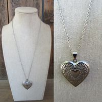 90s silver tone chain with heart locket. Lobster claw closure. Lightweight, costume jewelry. Very cute.  Chain is 20" Locket opens and closes and measures 1-1/8" x 1-1/8" Some light scuffing on underside, otherwise good with no other noted flaws.