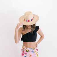 The Elena Palm Hat features a cotton woven band with pink, orange, white and navy stripes. Each one is handmade from palm fronds of the banks of the Chixoy River by our Guatemala female artisans. This hat collection is both sustainable and a fair trade partnership. With every hat purchase you make, we are able to continue sending orders to our talented partners giving them the means to support their families. Details: Permanent woven band attached to crown of hat Hat Brim measures 3 3/4" wide Cr