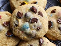 These Cadbury Egg Cookies are the perfect Easter cookie! The sweet chocolate eggs coated in the crunchy candy coating are perfect in the malted milk cookies...like a chocolate chip cookie, but better! #cookiesandcups #cadburyeggs #easterrecipe #eastercookies