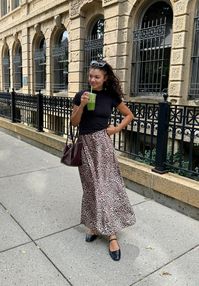 Recreate this leopard skirt outfit with mary jane flats, a black t-shirt, and a burgundy bag