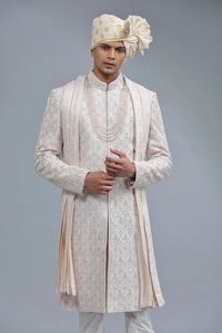 An amazing light peach raw silk sherwani is designed with embroidery, resham, beads, and sequins, which makes it an ideal selection for a groom. Comes with a matching bottom and dupatta as well.