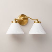 Illuminate your bedroom, living room or hallway in luxurious style with this Reeded Milk Glass 2-Bulb Vanity Wall Sconce from Hearth & Hand™ with Magnolia. Designed with two white reeded milk glass cone shades and a gold-tone metal fixture, this vanity wall sconce requires two E26 bulbs and features a one-way light setting. The sconce has no switch and requires hardwired installation (tools not provided), and it comes with the required mounting hardware to save you a bit of time. Hearth & Hand™