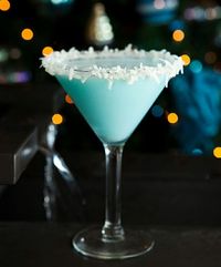 Snowball Martini 2 ounces vanilla vodka (Stolichnaya) 2 ounces Malibu rum 2 ounces Coco Lopez 1/4 ounce blue curacao Rim a martini glass with honey and fresh shredded coconut. Shake well and pour into a martini glass.