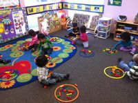 Teaching 2 year olds about personal space with hula hoop rings.