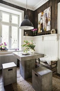 Love the mixture of styles in this room. Ornate crown moulding, rustic barn wood walls, and modern concrete table and stools.