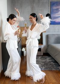 Start your wedding day in style with this luxurious silk bridal pajama set with feathers. The soft, flowing silk ensures ultimate comfort and a sophisticated look. The feather details on the sleeves and pants add a touch of glamour, making this set ideal for wedding preparations, bridal photoshoots, or as an elegant gift for the bride-to-be. * Handmade * High-quality soft Armani silk * Made to measure * Feathers on buttons (can be detached) * Sleeves and pants with ostrich feathers MORE PAJAMA S