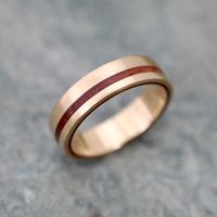 Ecofriendly Yellow Gold Equinox Guapinol Wood Ring with 100% Recycled Yellow Gold An offset stripe of Guapinol wood in 14k yellow gold. This unique design and process reveals the layers of wood on the side edge of the ring. An ecofriendly choice of wedding band, engagement ring, or commitment band... or a great day to day accessory. Please note that this listing is for one ring, but multiples may be ordered. Each ring is made to order in the size and width you request. Rings are available in who