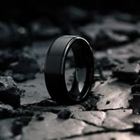 Modern black titanium wedding band designed with a raised brushed center and high-polish step-down edges. This ring has been crafted to perfection and designed for a comfortable fit. Ring Engraving Available. Available In Tungsten. Specifications Material: Titanium Exterior Features: Brushed textured top Exterior Features: High polish black edges Interior Features: High polish finish Fit: Comfort fit Ring Width: 8mm High scratch-resistances