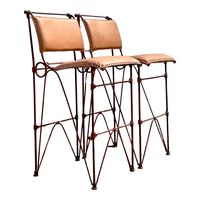 A fabulous pair of vintage bar stool done in the manner of Ilana Goor. The bar stools are in a brutalist style with bent rebar and leather seating. Acquired at a Palm Beach estate.