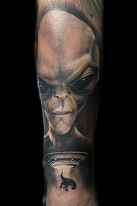 Black and grey realism alien with UFO abducting a T-Rex