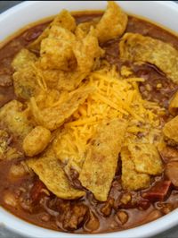 Hearty classic chili made easy. Spicy seasoned pinto beans slow-cooked all day with the best chili fixings like ham bone, ground beef, onions, peppers, garlic, and diced tomatoes.