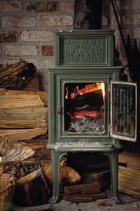 A wood-burning stove is one of the rustic touches in Gleeson's 1,000-square-foot cabin that houses the author's creative projects, including a sofa, left, reupholstered in fabric with an orange grove motif. Photo: Erin Gleeson