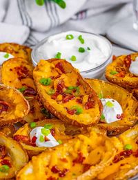 Ditch the restaurant and make your own Loaded Potato Skins at home. Crispy, tender and filled with cheese and bacon making a mouthwatering appetizer!