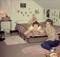 1960's -- attic bedroom, rollaway bed, metal TV tray table nightstand, throw rugs, curlers,rolled dungarees, and girltalk. [What am I missing?]