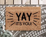 YAY IT'S YOU DOORMAT PLEASE READ: This doormat is made to be outdoors, however, it should be kept in a sheltered area such as a patio. The mat shouldn't be saturated with rain, snow, etc. If the doormats are saturated then it can cause fading or discoloration. Please note that Divine Ivy isn't responsible for any damaged caused by using the mat incorrectly. MATERIAL: 100% Natural Coir front with PVC backing SIZE: 18" x 30" & 1/2 inch thick CARE: Shake vigorously to clean and refresh Want It Cust