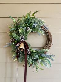 This crescent style wreath features mixed frosted greenery, berries, a large gold bell and a velvet bow. Choose your ribbon color at checkout.  Hang this winter wreath on your door or in your home now until spring!  This wreath is constructed on a 14 inch grapevine base and measures approximately 20 inches tall and 16 inches wide.  All my wreaths are packaged with care so they get to you safely.  For other available listings, please visit: www.emilysartisanwreaths.Etsy.com