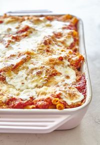 The smell of pasta, tomato sauce, and cheese baking together is one of life's most comforting scents. I know that what's going to come out of the oven will appeal to adults and children alike, feed a crowd without breaking the bank, and be just plain delicious. It's no wonder that baked ziti is the go-to for potlucks. Here's how to make an all-star pan of baked ziti — one that's never dry, made with a generous amount of cheese, and layered for the ultimate eating experience.