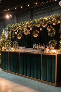 Green Velvet Winter Glam Bar: A luxurious green velvet bar accented with gold details, and frosted greenery to create a sophisticated holiday atmosphere. – Lux Holiday Themed Gala Party Decor