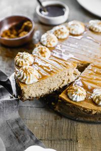 An easy Pumpkin Cheesecake recipe with a gingersnap cookie crust, topped with whipped cream and a drizzle of caramel sauce. Move over pumpkin pie, because this Pumpkin Cheesecake is ready to impress this holiday season!