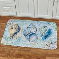 Three Sketchbook Shells are displayed in the center of this coastal memory foam cushioned mat. This ultra-soft polyester floor mat, .25" thick, has a printed design featuring seashells, coral, and script in shades of blue, green, cream, orange, and white.