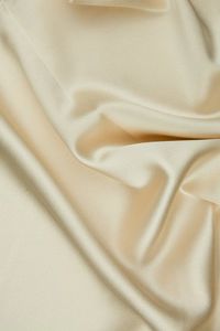 Frosted Almond Silk Crepe Back Satin Fabric is a lighter medium weight, shiny fabric with a similar look and drape to charmeuse. Distinguished by its luxurious design, this high-quality fabric is perfect for eveningwear, bridal/wedding, and lingerie. The face side of this fabric features a glossy satin finish while the back has a traditional pebbly crepe texture. Our unique and distinctive fabric is available in a wide selection of colors. The fabric is sold by the Yard, and measures 44 inches i