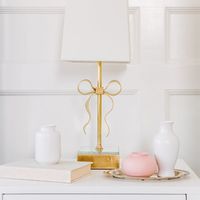 This lamp is a charming take on feminine sophistication. A decorative grosgrain bow, mirrored base, and linen shade add a dose of glamour to any space needing a feminine touch. Please allow 2-3 weeks for shipping.