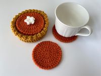 "More \"flavors\" coming soon! One of many MOD&MINIcrochet shop collectibles! This mini pumpkin pie coaster set of 5 is both delightful and functional! The bottom tart shell also acts as a coaster and holds 4 \"filling\" coasters. The top coaster has a dollop of whipped cream. The top coaster has an optional dollop of whipped cream due to whipped cream topping can make the top coaster slightly unstable when used.  When they're not in use, stack them in the tart shell and you have an adorable decoration. Perfect for home and work decor as well as birthday and holiday gifts! Size: Total height is approximately 2 inches tall. Total diameter of tart shell is approximately 4.5 inches. Diameter of \"filling\" coasters is approximately 3.5 inches. Note: These are lovingly handmade - details, colo