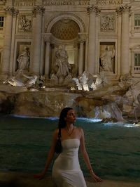 A girl siting on the edge of the Fontain Di Trevi in Rome city centre