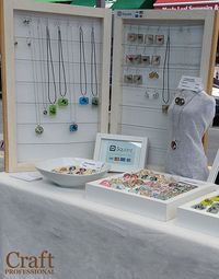 All-white jewelry display at an outdoor market.