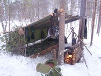 This is how to set up a backwoods camp.  I might add an additional tarp to one of the sides to cut down on wind.