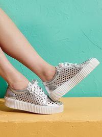 An easy sneaker is made modern with a layered-look platform sole and laser-cut geometric perforations.