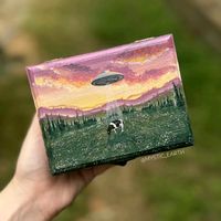 A dreamy landscape scene of a ufo abducting a cow! the siding and inside of the box is stained with dark brown. available on my site or linked below 

Mystic Earth by Annabell Larsh 

#witch #fairy #cottagecore #cow #jewelrystorage #handmade #craft #etsy #smallbusinessowner #illustration #painting #landscape #nature #mountains #acrylic #field #homedesign #homedecor #inspo