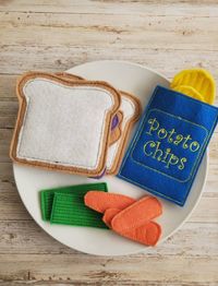 Your Little is going to have a ton of fun playing and learning with this Peanut Butter Lunch Pretend Play Food set! It's a wonderful alternative to hard plastic play food. The full set includes 1 sandwich, one chip set, a fruit or veggie.  These chips each have one bag and 3 chips.  Each one made from safe and soft felt fabrics.  The details are embroidered using an embroidery machine. The sandwich bread is 3.5 inches Chip bags are 3.75 inches This felt play food set is a great gift idea for you