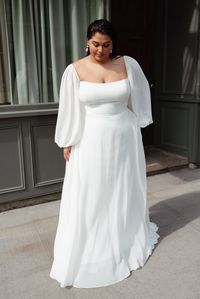 The Louise wedding dress is as chic as she is romantic. Cut in our luxe chiffon fabric, the sleek square neckline balanced by beautifully dramatic, voluminous long sleeves. Elastic shoulders and cuffs lend the sleeves comfort and versatility. The structured bodice gives way to a full, flowing A-line skirt for a classic and flattering silhouette.