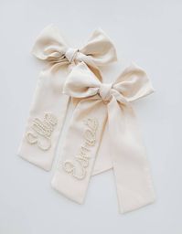 Hand beaded satin bow. Each bow is made to order so can take anywhere from 1-3 weeks.  Finish: Alligator Clip * 9 inches long * Material: Satin