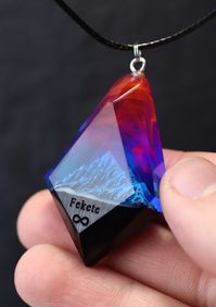 Handmade Northern lights pendant from black hornbeam wood and epoxy resin with snow mountains inside. Glow in the dark!