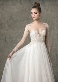 The Baylee wedding dress has a natural waist sparkle tulle A-line skirt with long sleeve illusion sweetheart lining. There is ivory beading through bodice and sleeves with buttons down center back. #wedding #weddingdress #longsleeveweddingdress #longsleevedweddingdress #weddingideas #weddingplanning #weddingdressstyles #bridalgown #ballgown #weddingdresses